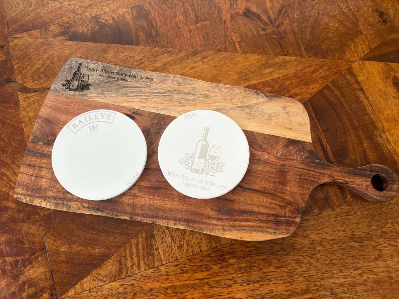 Custom engraved wooden cheese board with two personalised ceramic drink coasters
